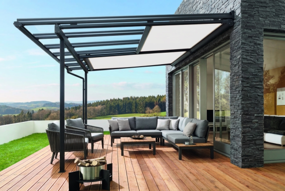Terrassenüberdachung mit integrierter Beschattung und Lounge Sitzbereich auf Holzterrasse