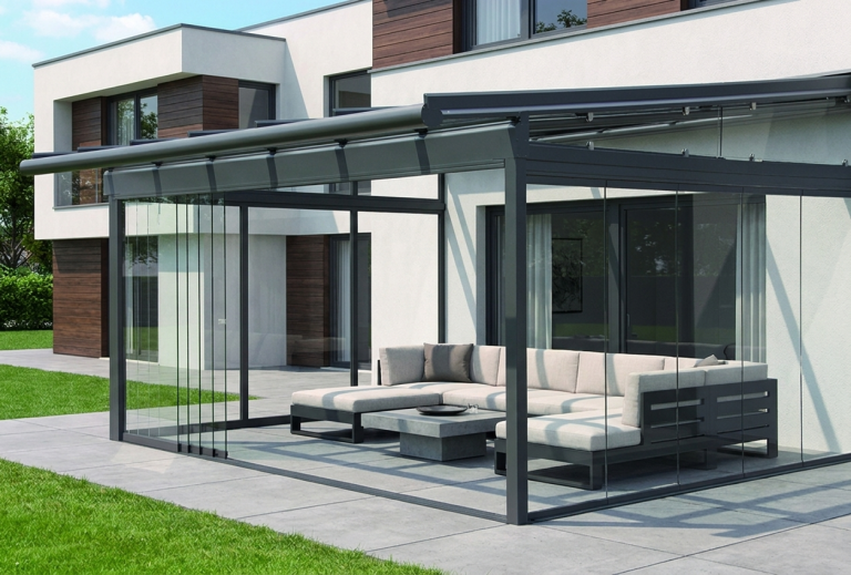 Terrassenüberdachung mit seitlichen Glaselementen und gemütlicher Sitzecke