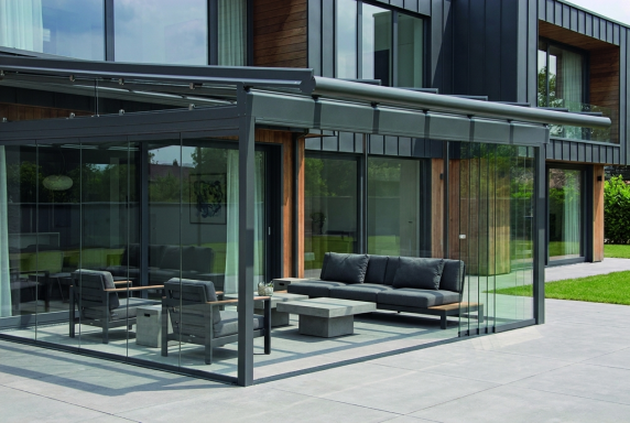 Moderne Terrassenüberdachung mit Glasdach und Sitzbereich am Einfamilienhaus in Hannover