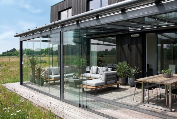 Terrassenüberdachung mit Glasschiebewänden geschützter Outdoor Wohnbereich bei jedem Wetter